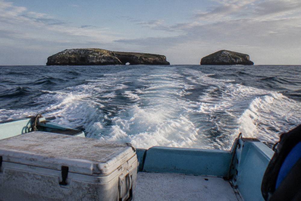 Open water of Banderas Bay with a boat wake trailing toward the Marietas Islands on the horizon